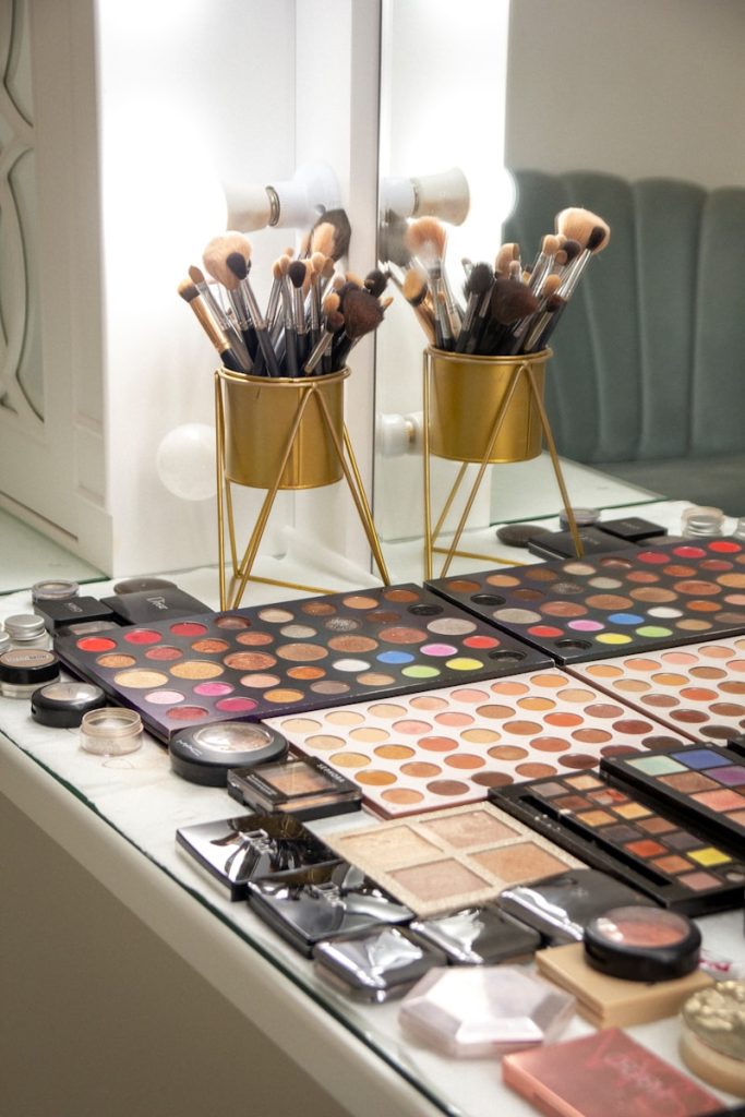 a table topped with lots of makeup and brushes